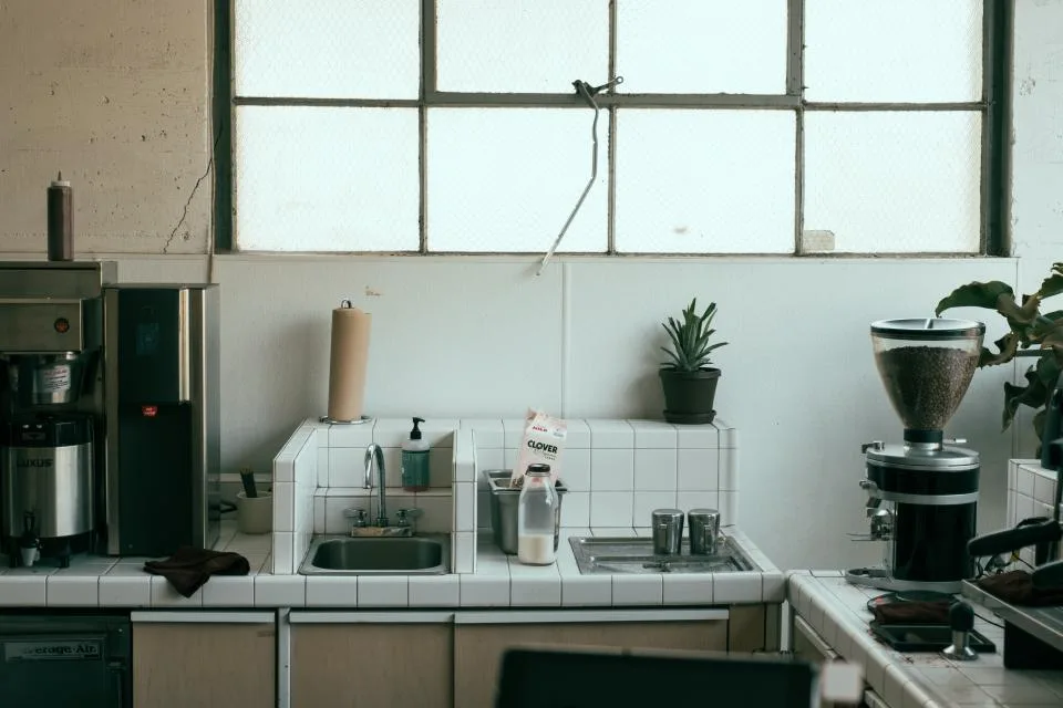 White tile splashback beneath steel windows
